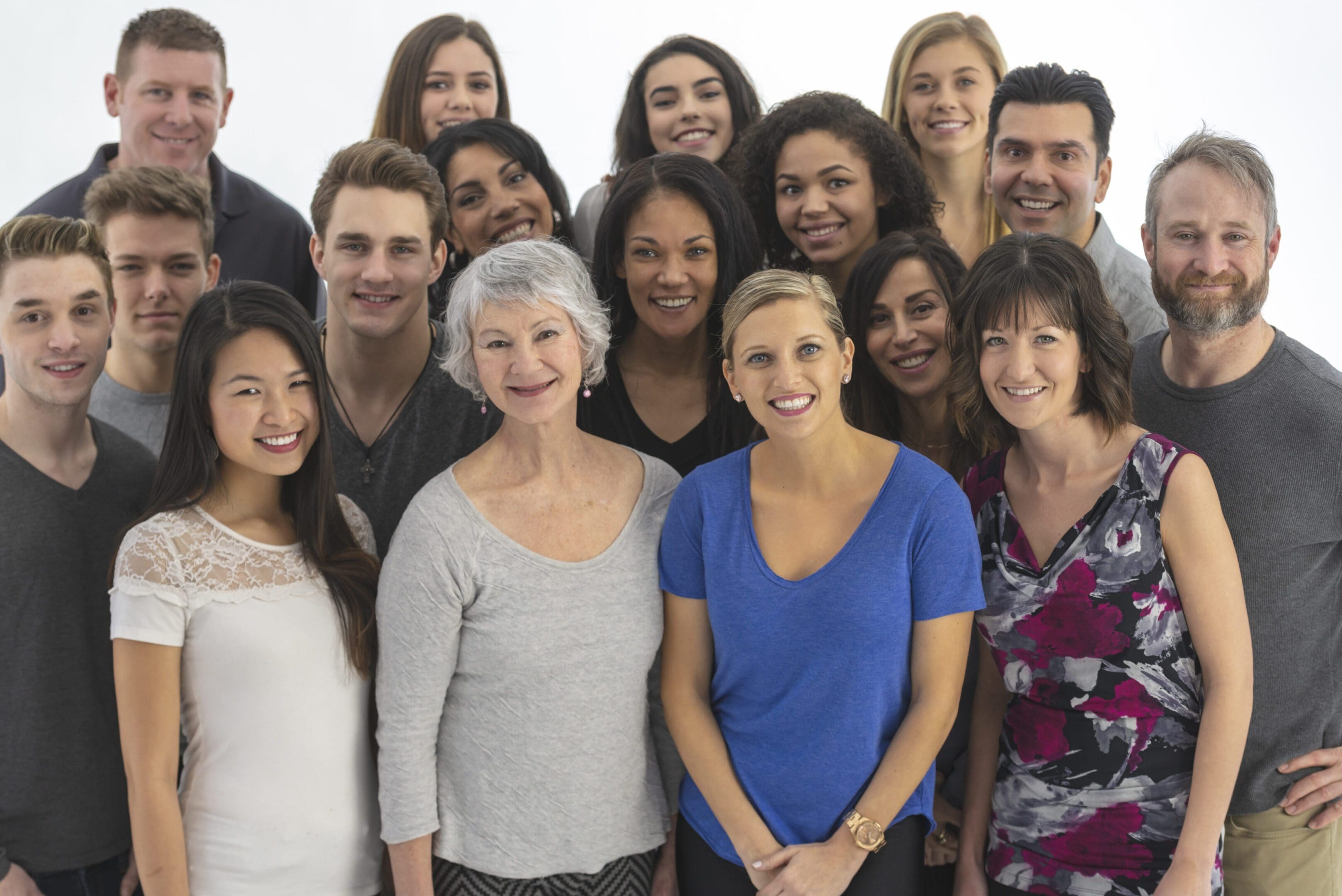 A diverse group of smiling people posing together indoors.