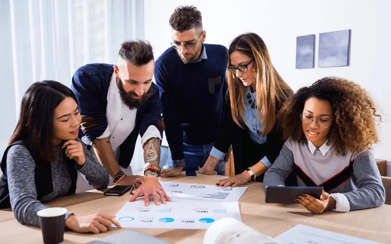 Team collaborating on a project at table.